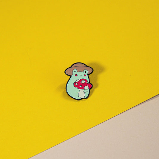 Cute Frog Enamel Pin Holding Mushroom with Hat – Whimsical Animal Accessory, Perfect for Backpacks, Jackets, and Collectibles
